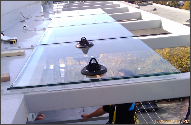 The Jims - Highrise apartment condo glass Canopy System. Glass canopy panels were cut to fit the existing steel frames. Angel Glass installers setup safety harness for installers and had glass canopy installed.