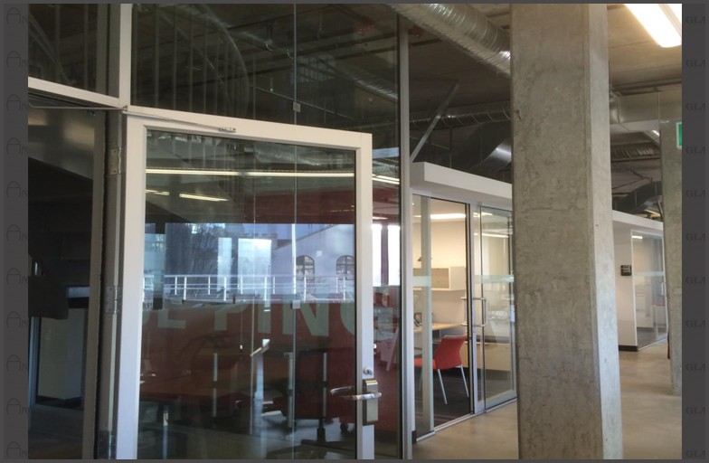 Fire rated stairwell needing glass door and glass wall with cutouts for sprinklers. Angel Glass designed, engineered, cut and installed all the glass wall panels, steel posts to support glass wall panels, and glass door had lever handles that allows for emergency access in and out.