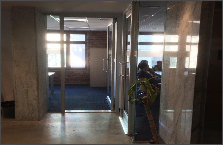 Glass door that swings into offices. These glass doors were designed and installed by Angel Glass designers and installers to meet office requirements.