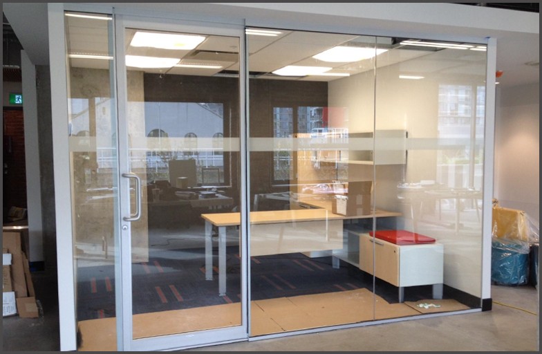 Sliding glass doors installed into this office room. Aluminum framed sliding door with clear tempered glass panels.