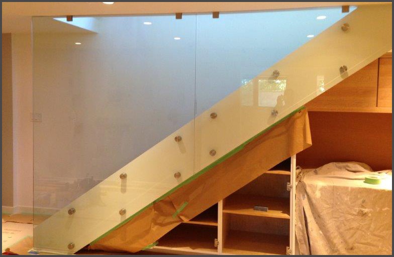Terris Lightfoot - Glass railing designed, cut, build, installed by Angel Glass installers. Using metal standoff bolts, glass railing panels got bolted to side of wood stairs.