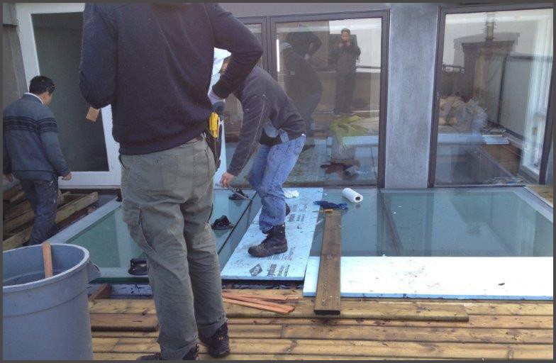 Glass roof panels being installed by Angel Glass installers. Glass had been engineered with safety glass and non slip surfaces that allows for our installers to walk on it and do their installation work. Before glass roof skylight being installed, our installers had to install all the aluminum metal frames that had been engineered to support this glass roof.