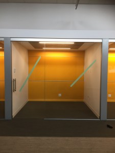 Another completed office room fitted with sliding glass door, glass wall, and colored glass writing board installed onto back walls.