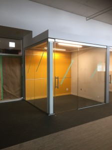 Sliding glass doors and glass walls were designed in conjunction with the owners architect and builder. Once completed this office room provides the office person a full exterior office view while providing them with noise resistant once sliding doors are closed. Color glass on the wall provided another usable place for the office person to be able to write on using markers so they could write information on this glass wall, and when they are done with the notes they would be able to wipe it off with a wet cloth.