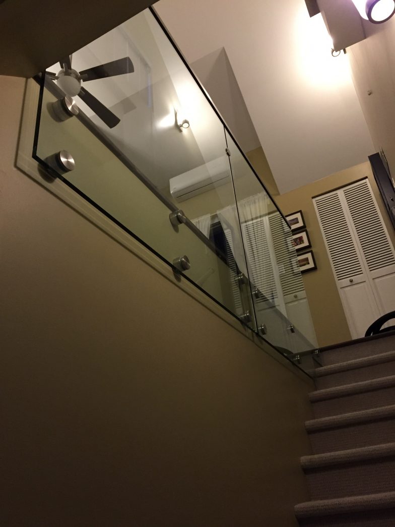 glass railing with bolts leading from staircase